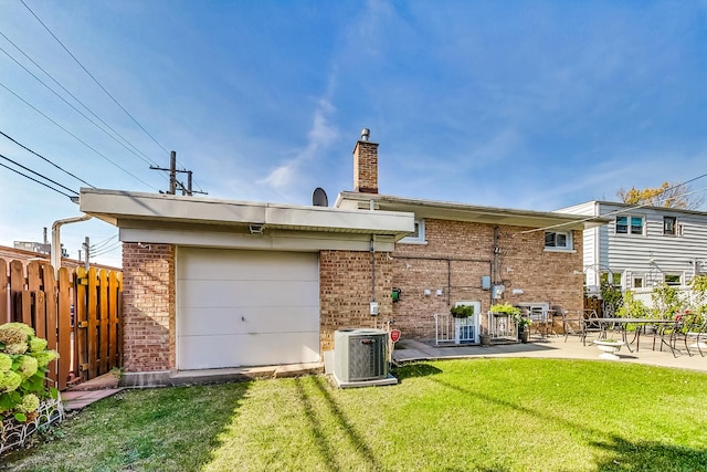 rear view of property with cooling unit, brick siding, fence, a lawn, and a patio area