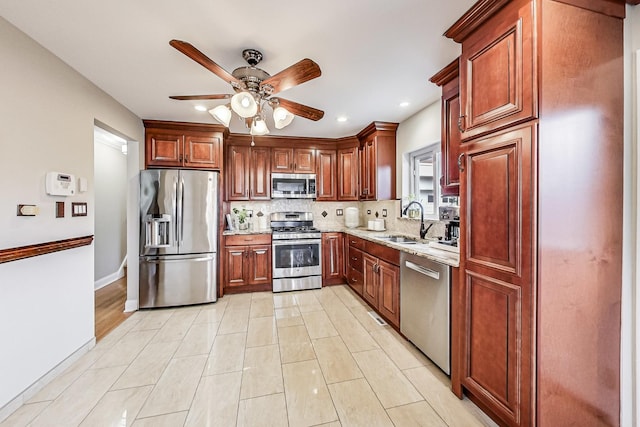 kitchen featuring recessed lighting, stainless steel appliances, a sink, a ceiling fan, and backsplash