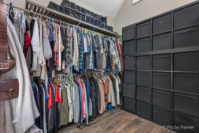 spacious closet featuring wood finished floors and vaulted ceiling