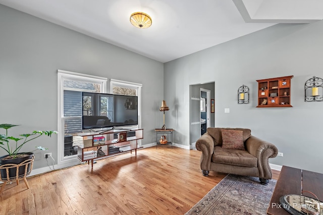 living area featuring baseboards and wood finished floors