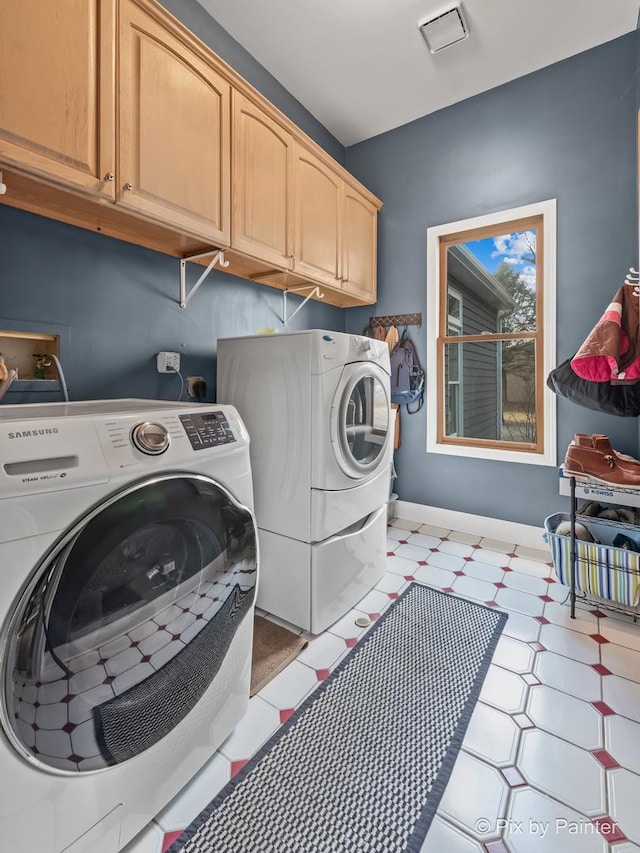 laundry area with baseboards, cabinet space, light floors, and washer and clothes dryer