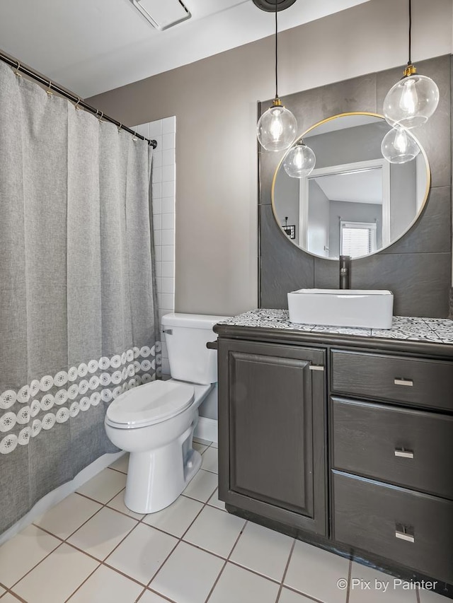 full bath with toilet, vanity, and tile patterned flooring