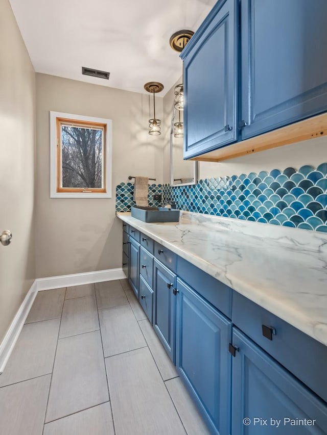 bathroom with tasteful backsplash, visible vents, vanity, and baseboards