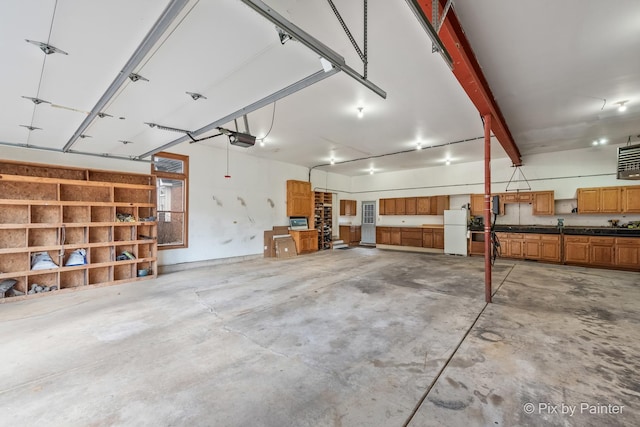 garage with a garage door opener and freestanding refrigerator