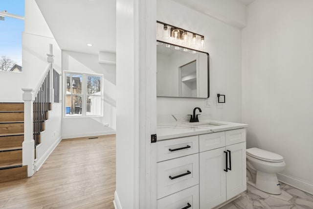 bathroom with recessed lighting, toilet, vanity, wood finished floors, and baseboards