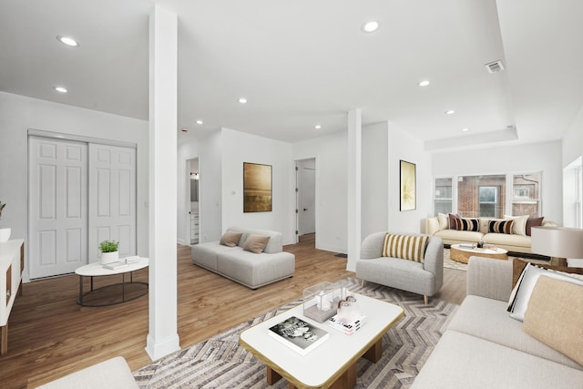 living area with light wood finished floors, visible vents, and recessed lighting