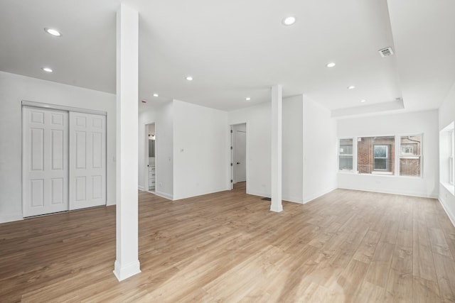 unfurnished living room featuring baseboards, light wood finished floors, visible vents, and recessed lighting