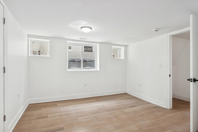 spare room with baseboards, visible vents, and light wood finished floors