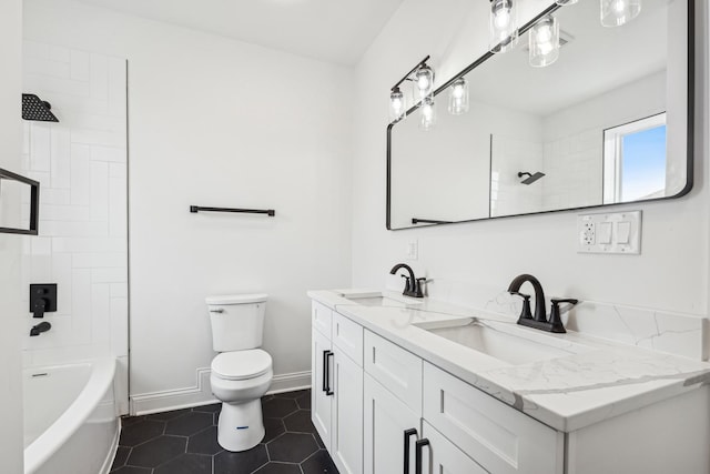 bathroom with toilet, tile patterned flooring, baseboards, and a sink