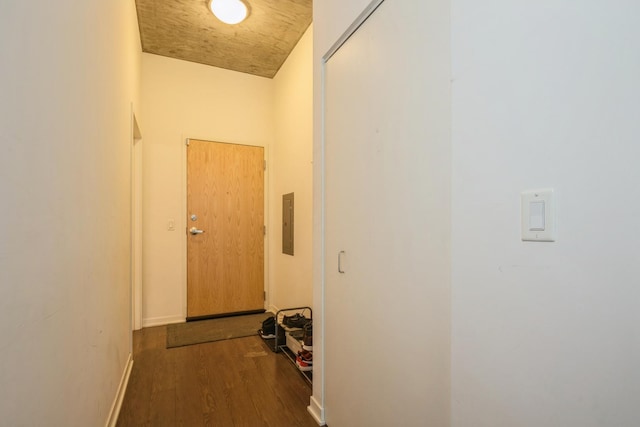 hallway featuring electric panel, baseboards, and dark wood finished floors