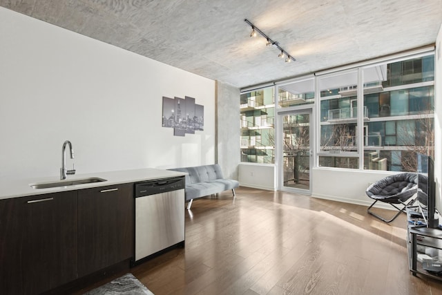 interior space with a sink, rail lighting, stainless steel dishwasher, and wood finished floors