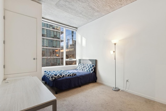 bedroom featuring light colored carpet and baseboards