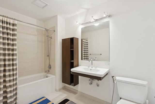 bathroom featuring toilet, shower / tub combo, visible vents, and a sink