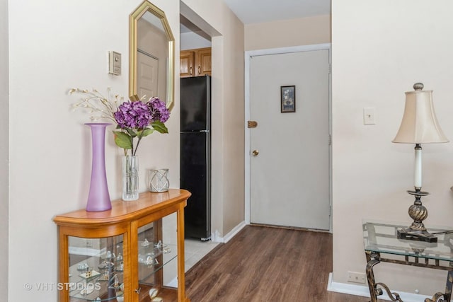 corridor featuring dark wood-style flooring and baseboards