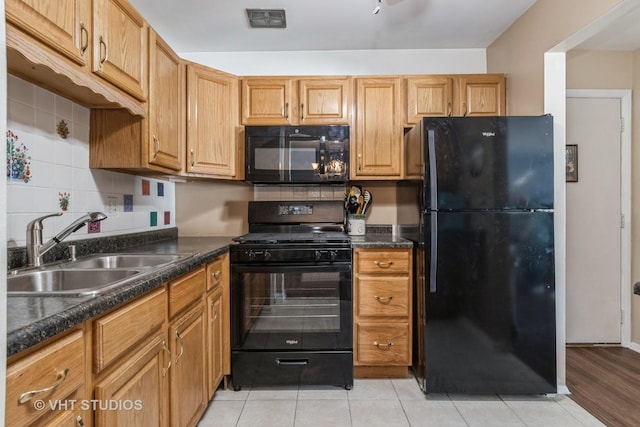 kitchen with visible vents, decorative backsplash, brown cabinets, black appliances, and a sink