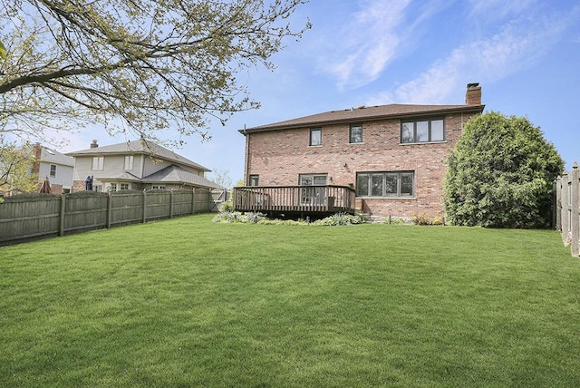 rear view of property featuring a wooden deck, a chimney, and brick siding
