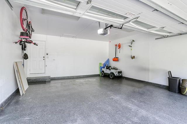 garage with a garage door opener and baseboards