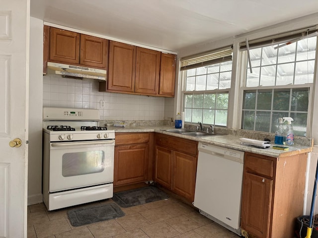 kitchen with light countertops, decorative backsplash, a sink, white appliances, and under cabinet range hood