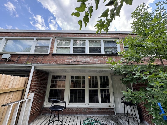 exterior space featuring fence and brick siding