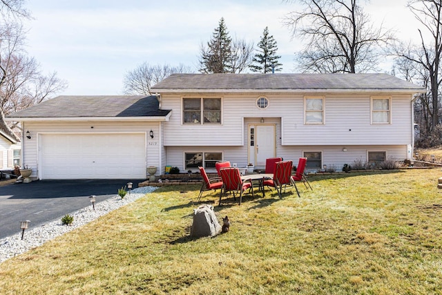 view of front facade with aphalt driveway, a front yard, and an attached garage