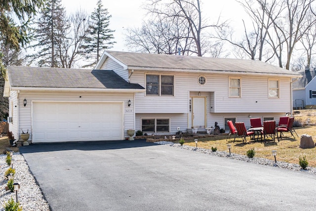 bi-level home featuring a garage and driveway