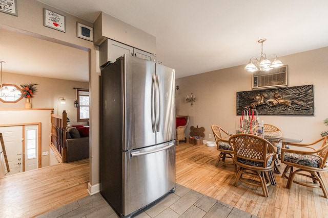 kitchen featuring light wood-type flooring, baseboards, an inviting chandelier, and freestanding refrigerator