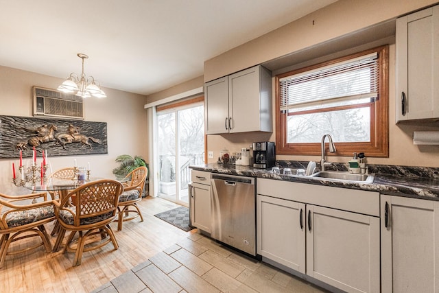 kitchen with an inviting chandelier, light wood-style flooring, a sink, dishwasher, and dark countertops