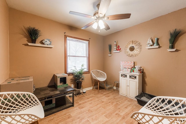 interior space with baseboards, a ceiling fan, and light wood-style floors