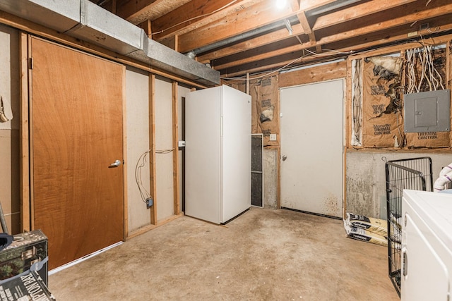 unfinished basement featuring electric panel, washer / clothes dryer, and freestanding refrigerator