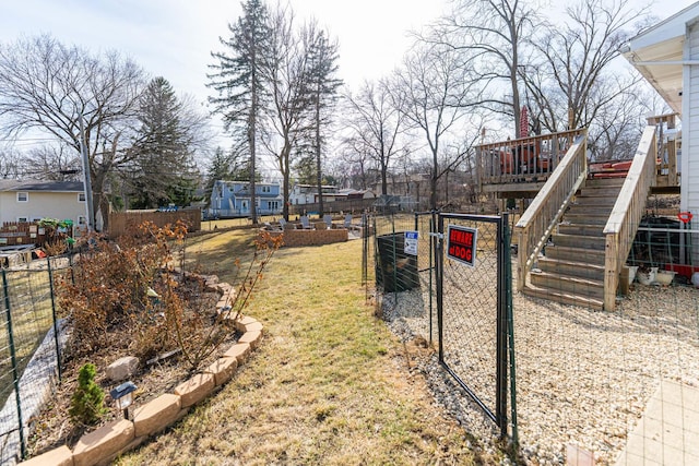 view of yard featuring fence, stairs, and a gate