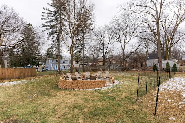 view of yard with a fire pit, fence, and a residential view