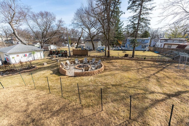 view of yard with a fire pit, fence, and a residential view