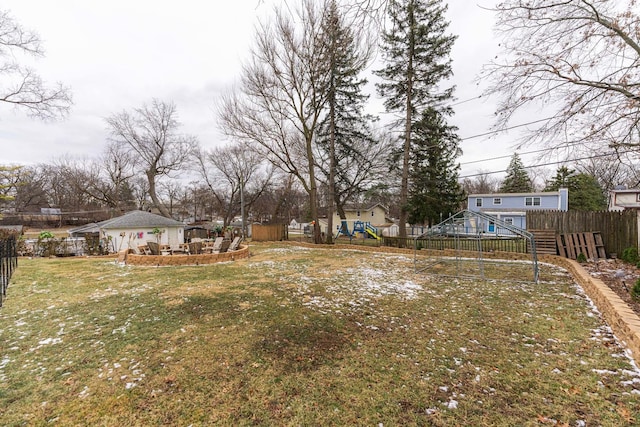 view of yard featuring a residential view, a playground, and fence