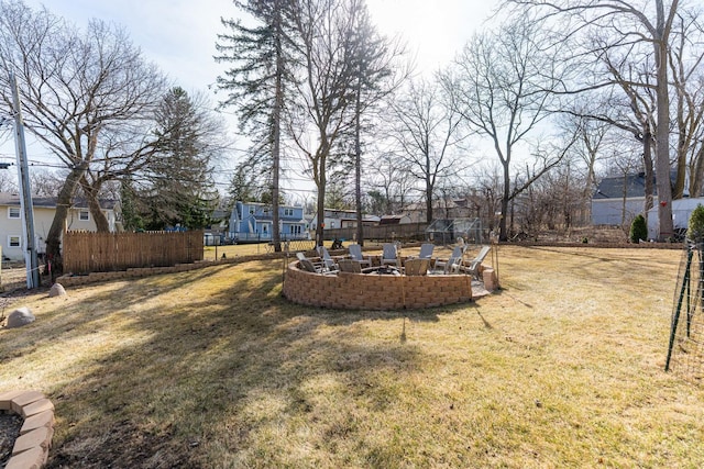 view of yard with a fire pit, fence, and a residential view