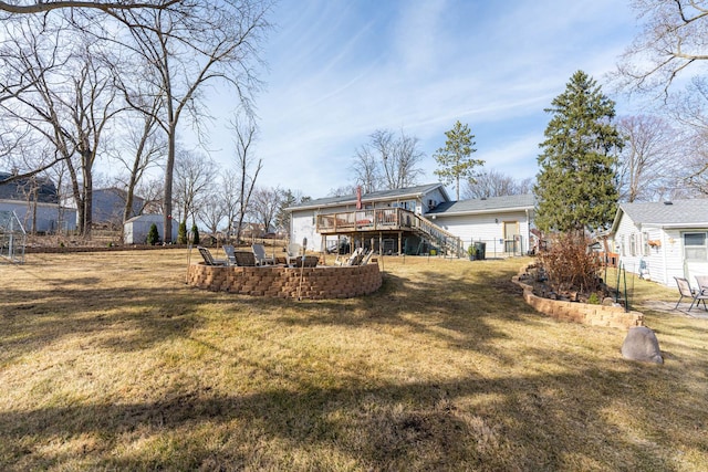 view of yard featuring fence, a wooden deck, stairs, an outdoor structure, and a storage unit