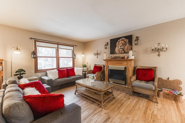 living area with light wood-type flooring and a glass covered fireplace