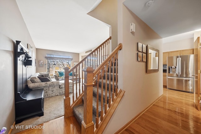 stairs featuring wood finished floors and baseboards