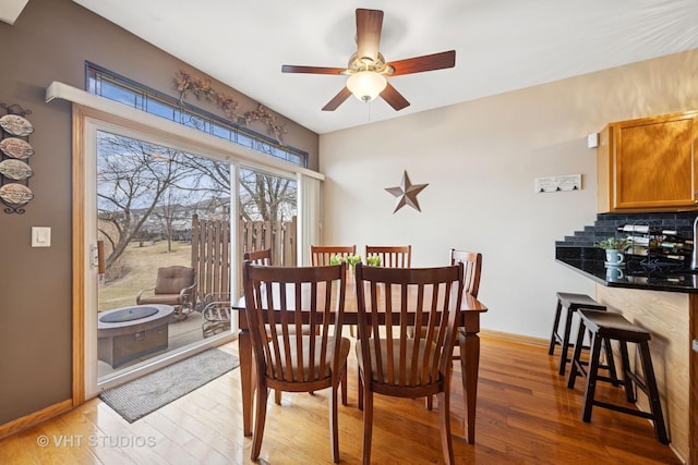 dining space featuring light wood-style floors, ceiling fan, and baseboards