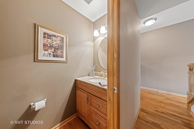 bathroom featuring vanity, baseboards, and wood finished floors