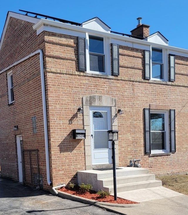 multi unit property featuring brick siding and a chimney