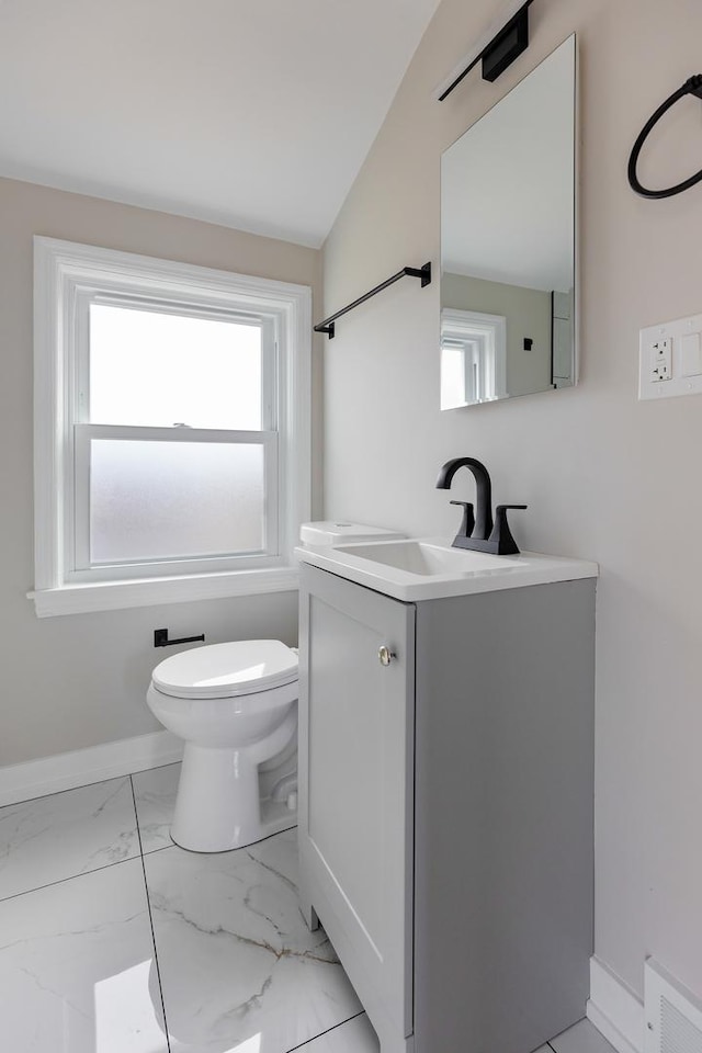 half bathroom with toilet, visible vents, vanity, baseboards, and marble finish floor