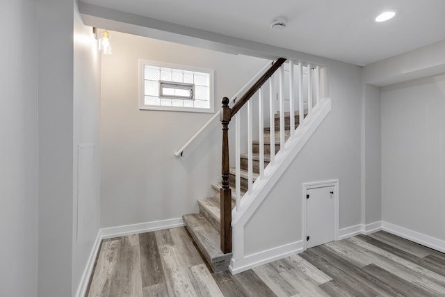 staircase with recessed lighting, wood finished floors, and baseboards