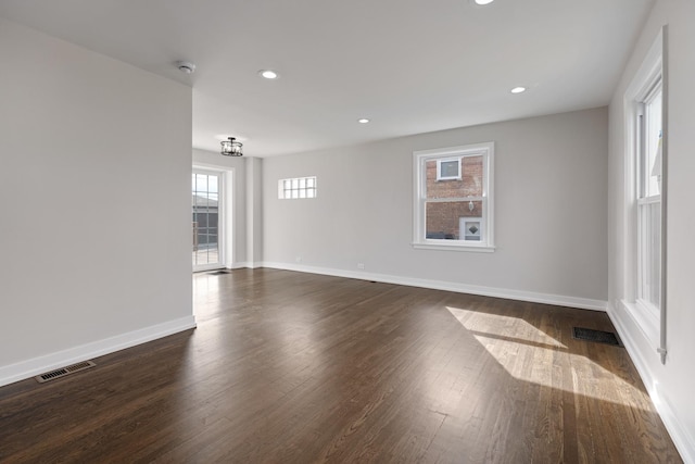 empty room featuring recessed lighting, visible vents, dark wood finished floors, and baseboards