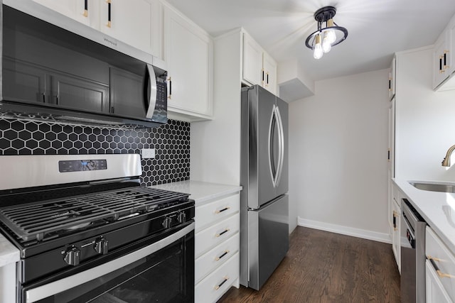 kitchen featuring dark wood-style floors, stainless steel appliances, tasteful backsplash, white cabinetry, and a sink