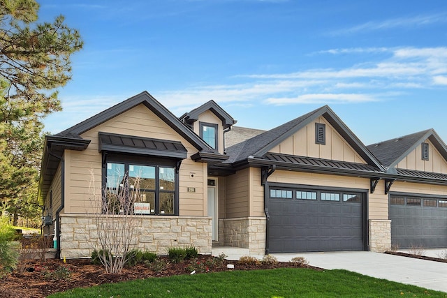 view of front of house with board and batten siding, a standing seam roof, an attached garage, and concrete driveway