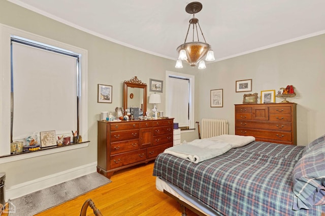 bedroom featuring radiator, light wood-type flooring, ornamental molding, and a chandelier