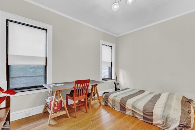 bedroom featuring ornamental molding, baseboards, and wood finished floors