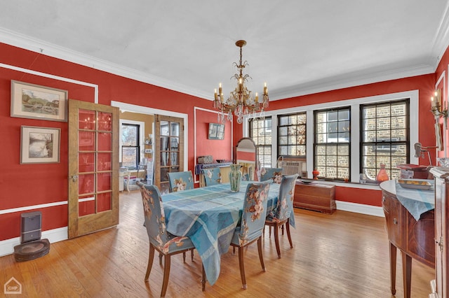 dining room featuring baseboards, ornamental molding, french doors, hardwood / wood-style floors, and an inviting chandelier