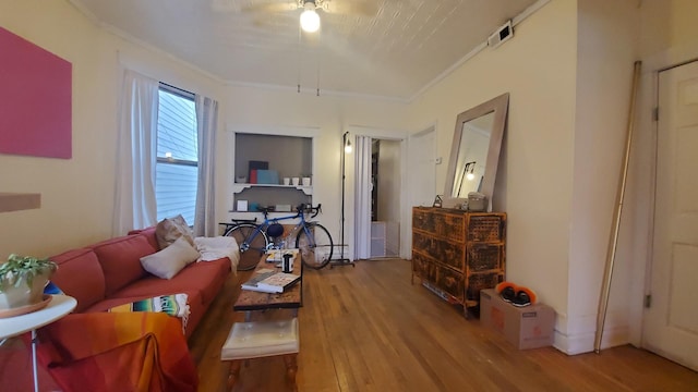 living room featuring ornamental molding and wood finished floors