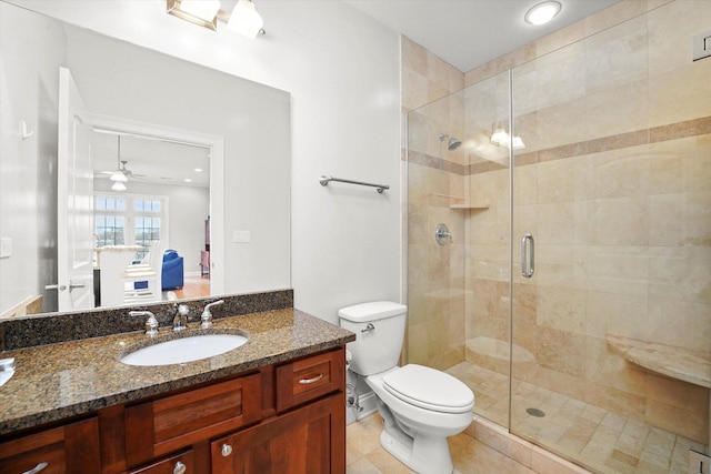 bathroom featuring vanity, a shower stall, toilet, and tile patterned floors